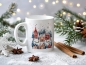 Preview: Weiße Keramiktasse mit festlichem Winterdorf-Motiv, dekoriert mit Zimtstangen, Sternanis und glitzerndem Kunstschnee, vor einem weihnachtlichen Hintergrund mit leuchtenden Lichtern und grünen Tannenzweigen.